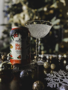 Re-Frsh Effervescent Botanical poured into a fancy Christmas glass in front of a Christmas tree